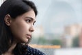 Close up frustrated thoughtful Asian woman looking out window