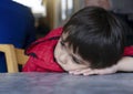 Close up frustrated young kid, Lonely little boy sitting alone and looking down with bored face,Unhappy Preschool child with sad