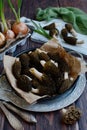 Close-up of a frying pan with fresh morel mushrooms on a brown wooden background. Vertical. The first spring edible Royalty Free Stock Photo