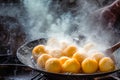 Close-up of a frying pan where fritters are being fried and cooked. Typical Easter and Carnival sweets