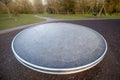 Close up of fun metal roundabout disc in children's outdoor playground. Modern design, urban park. Royalty Free Stock Photo