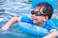 Close up funny asian boy with swim tube in pool. Outdoor. Royalty Free Stock Photo