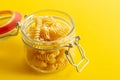 Close up of fusilli pasta in galss jar on yellow background