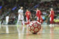 Close up of futsal ball with players in the background