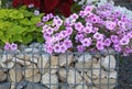 Close-up of a gabion support wall with wire mesh reinforcement topped with pebbles and tiles Royalty Free Stock Photo