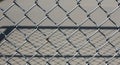 Close up of galvanized chain link fence showing diamond pattern and light shadows clearly defined Royalty Free Stock Photo