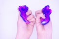 Two-color blue and pink slime in someone's hands on a white background. The mucus is crushed stretched 