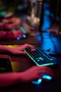 Close-up of the gamers hand movements on the glowing keyboard and mouse