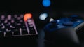 Close-up of a gaming setup, consisting of a controller and a keyboard on a desk