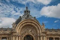 Close-up of garish decoration in the dome and arch gate of the Petit Palais on sunny day in Paris.