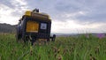 Close up of gas diesel mobile portable electricity generator work on grass. Gasoline fuel powered portable generator