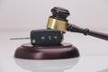 Close-up Of Gavel And Car Key On Sounding Block Against Grey Royalty Free Stock Photo