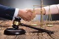 Close-up Of A Gavel And Scale On Wooden Desk