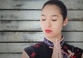 Close up of geisha with hands together against grey wood panel Royalty Free Stock Photo