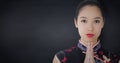 Close up of geisha hands together against navy chalkboard