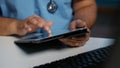 Close up of general practitioner nurse holding tablet computer typing medical expertise Royalty Free Stock Photo