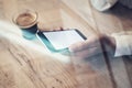 Close up of generic design smartphone with blank screen holding in female hand. Cup espresso on the table, horizontal, visual effe