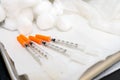 Close up of generic needle syringes with orange caps, for diabetes insulin injections, or medical injection formulas in a doctor