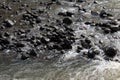 Close up of gently rushing water over slippery, wet pebbles at Ho\'olawa Stream in Haiku, Maui