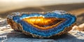 Close up of a geode with blue and yellow crystals on a rock surface in the sunlight outdoors Royalty Free Stock Photo