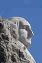 Close up of George Washington`s head on Mount Rushmore with solid blue sky
