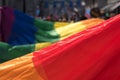 Close up of the giant rainbow LGBT flag at the front of the Gay Pride Parade in London 2018, with people holding the edges.