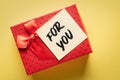 Close-up of a gift box with a note with the words for you on a yellow background: expression of gratitude or love Royalty Free Stock Photo