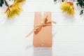 Close-up gift box tied with ribbon among fresh orange and yellow Royalty Free Stock Photo