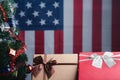 Close-up of gift boxes and a Christmas tree with an American flag in the background. Space for text. Concept of Christmas and new Royalty Free Stock Photo