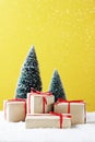 Gift boxes, Christmas tree on table and yellow background. Royalty Free Stock Photo
