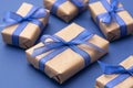 Close up gift boxes, presents. Craft paper wrapped gift boxes on blue background Royalty Free Stock Photo