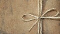 Close up of gift with copy space, tied knot on rough organic paper