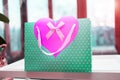 Close-up gift green package with a pink heart on the windowsill Royalty Free Stock Photo