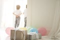 Close up of giftboxes and colorful balloons prepared for celebrating holiday with two curious latin twin boys, children