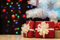 Close-up of gifts under a decorated Christmas tree against a bac