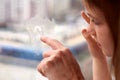 Close-up view of girl and an adult`s hand draws on glass of window