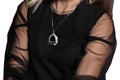 Close-up of girl in black translucent dress on her arms and a pendant around the neck, fashion and style of clothing on white