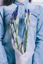 Close-up of a girl in a denim shirt holding a bouquet of unblown flowers iris Royalty Free Stock Photo