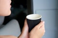 Close-up of a girl drinking coffee from a black cardboard cup Royalty Free Stock Photo