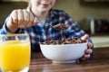 Close Up Of Girl Eating Bowl Of Sugary Breakfast Cereal In Kitchen