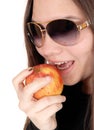 Close up of girl eating a red apple with sunglasses Royalty Free Stock Photo