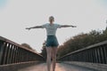 Close-up of girl exercising on wooden bridge. Tranquility at sunset