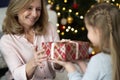 Close up of little girl giving a Christmas gift to her grandmother Royalty Free Stock Photo