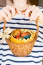 Close up girl holding colorful Easter eggs in a basket Royalty Free Stock Photo