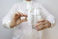 Close up. the girl is holding a pill and a glass of water Royalty Free Stock Photo