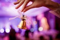 Girl holds in hand a Christmas bell on lights background Royalty Free Stock Photo