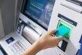 Close up of a girl inserting a credit card in ATM bank machine to transfer money or withdraw. Finance customer and banking service Royalty Free Stock Photo