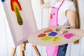 close up girl painting canvas holding multicolored wooden palette hand. High quality photo Royalty Free Stock Photo