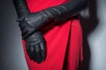 Close-up of a girl in a red designer skirt, with black leather gloves. Fashionable look. Advertising photo for the catalog