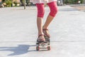 Close up of girl`s feet standing on modern short cruiser skatebo